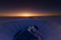 The BICEP2 telescope at twilight, which occurs only twice a year at the South Pole. The MAPO observatory (home of the Keck Array telescope) and the South Pole station can be seen in the background. (<i>Steffen Richter, Harvard University</i>)